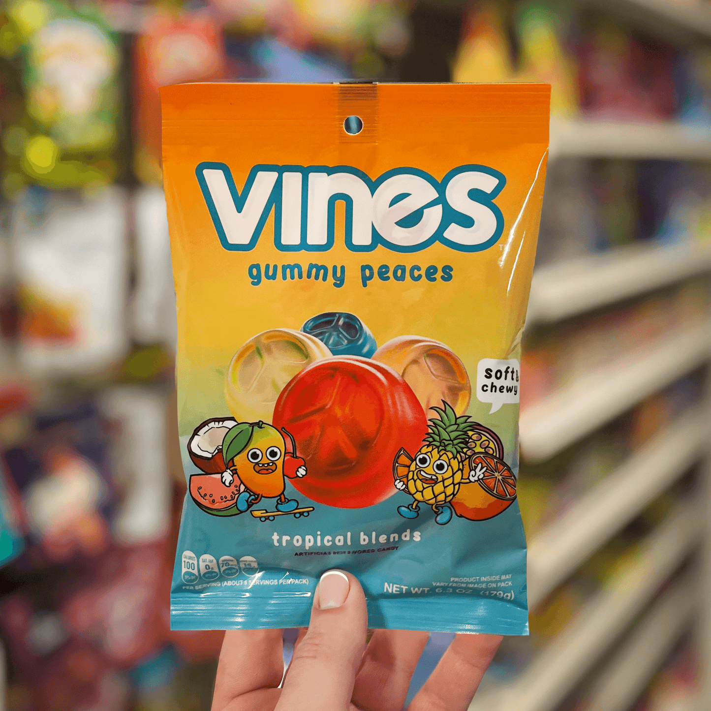 Vines Gummies tropical blends wholesale gummy candy 6.3oz bag in someone's hand in the candy aisle