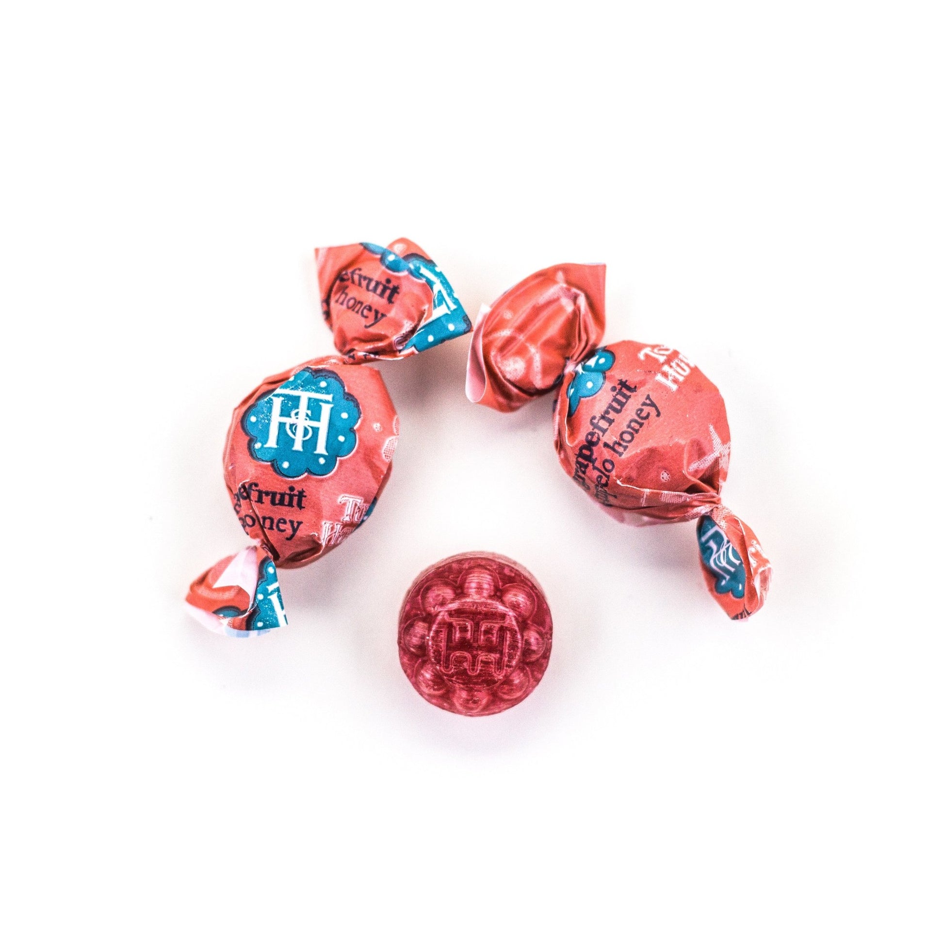 Two wrapped and one unwrapped Grapefruit & Honey Organic Hard Candies