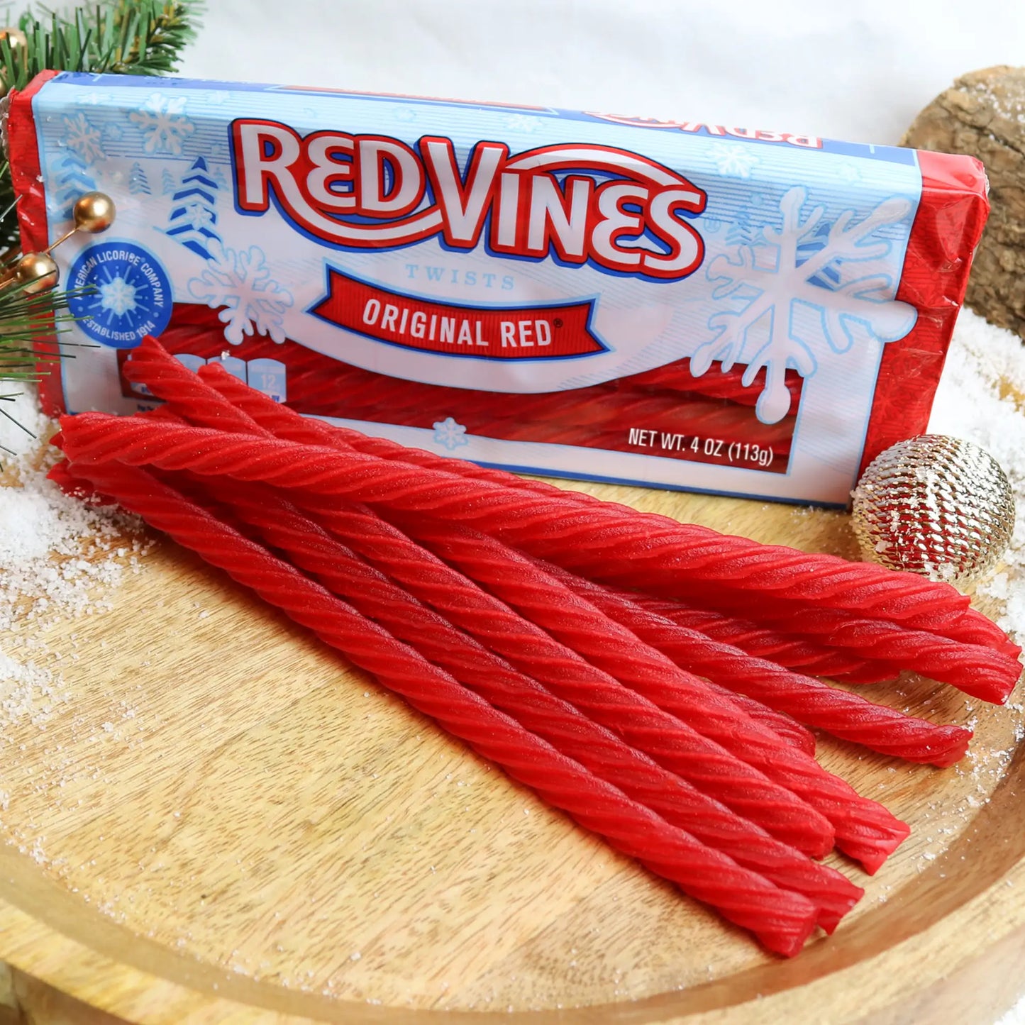 Red Vines Original Red 4oz Winter Tray on a wooden platter with fake snow and holiday ornaments