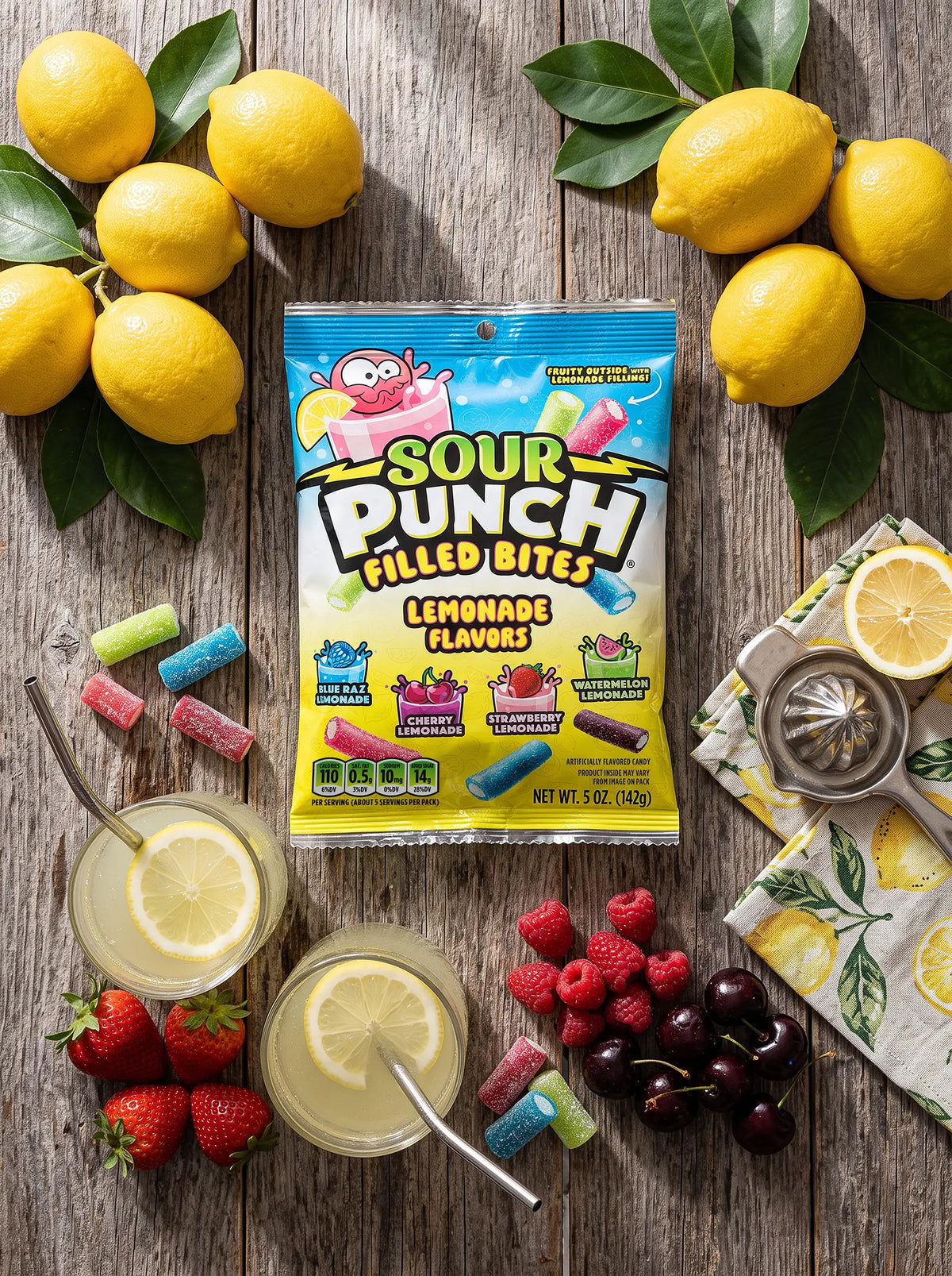 Sour Punch Lemonade Filled Bites 5oz Bag on a table with fresh fruits, lemonade, and seasonal berries