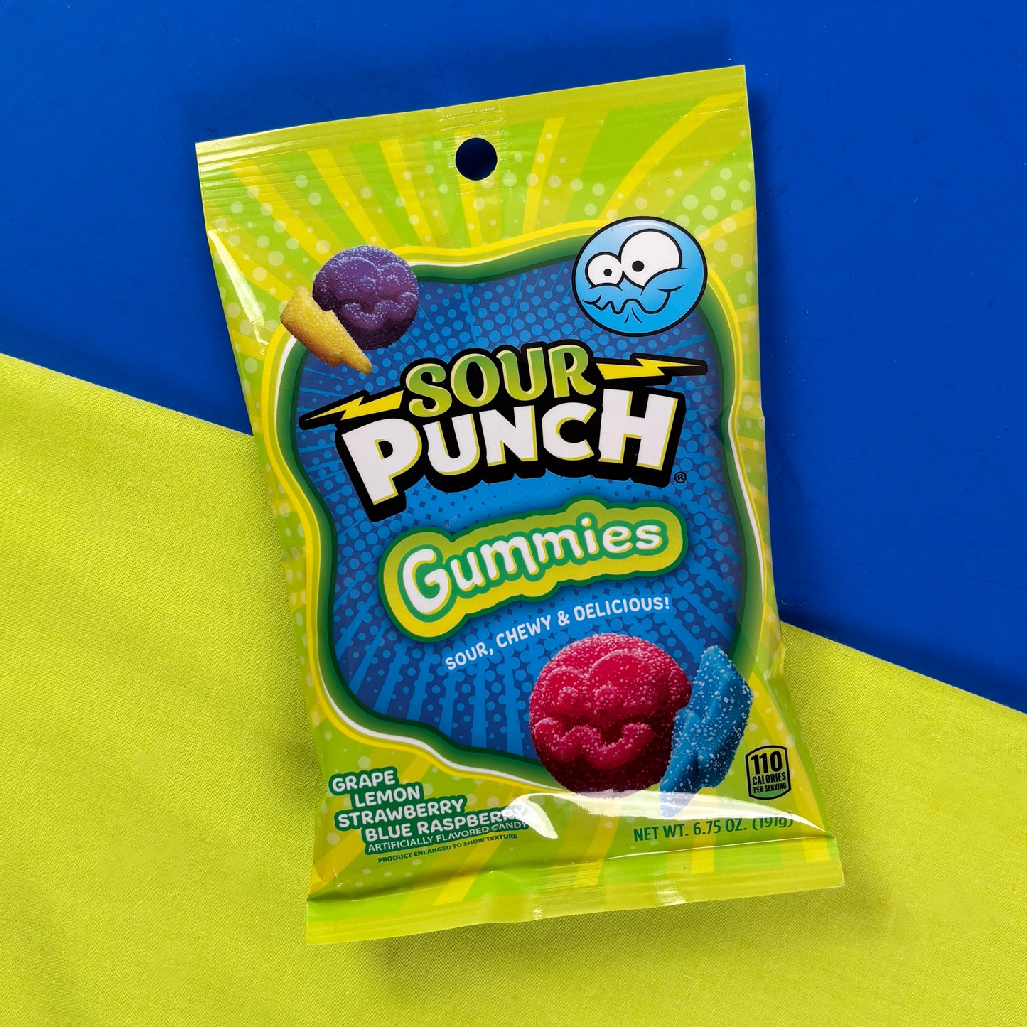 Sour Punch Gummies on a blue and yellow split background