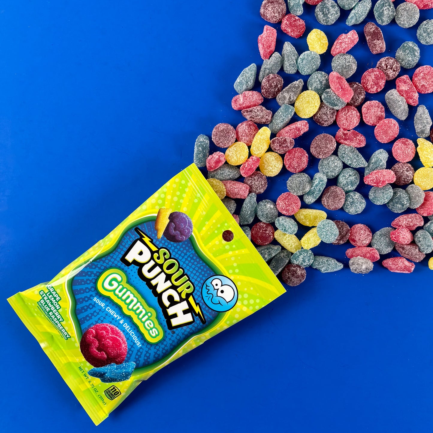 Sour Punch Gummies on a blue background with raw candy shapes falling out of the bag