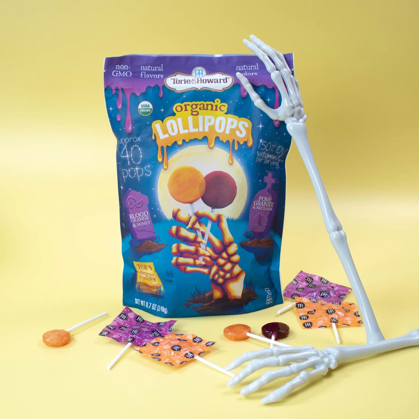 Torie & Howard Organic Lollipops Wholesale Halloween Candy 8.7oz Bag with lollipops out of bag and skeleton arm props