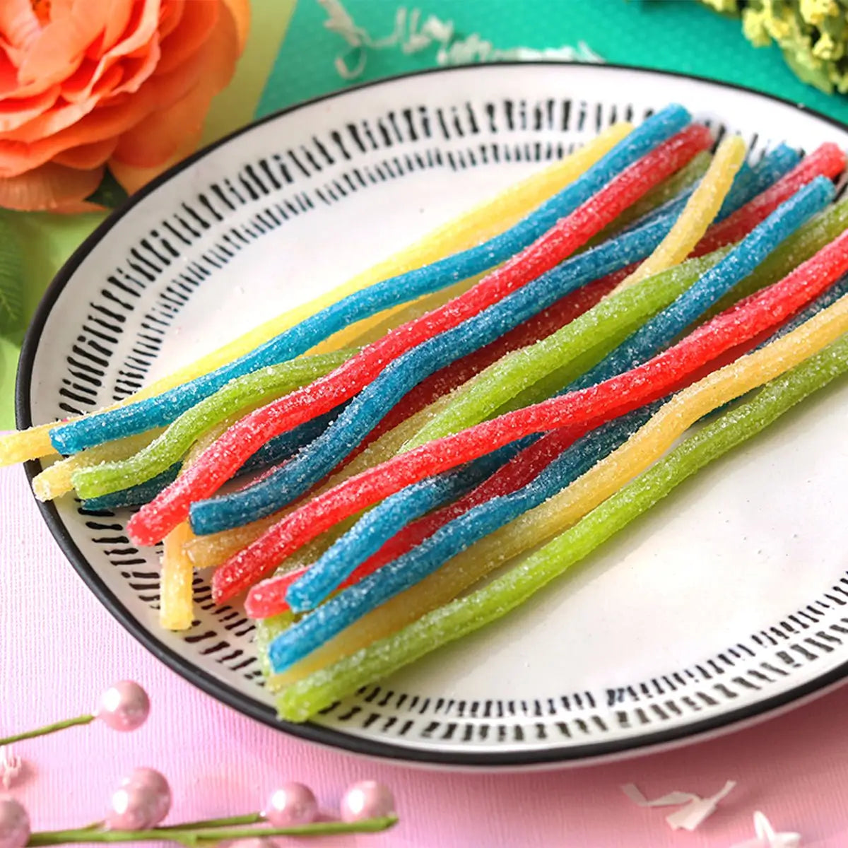 Strawberry, Lemon, Green Apple, and Blue Raspberry sour straws on a serving plater