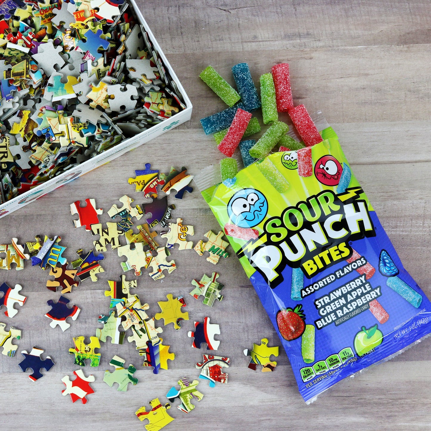 Putting together a puzzle while enjoying an open bag of Sour Punch Assorted Bites