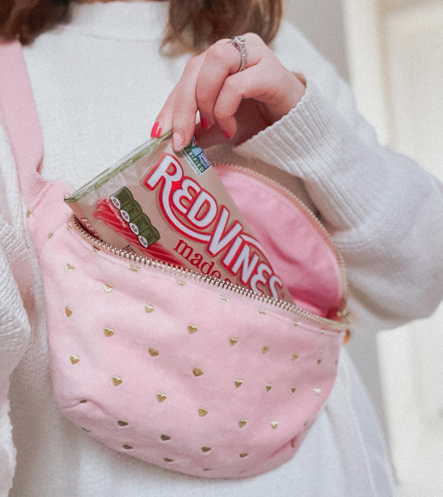 Pulling a Red Vines Made Simple Berry Licorice Twists Tray out of a shoulder bag